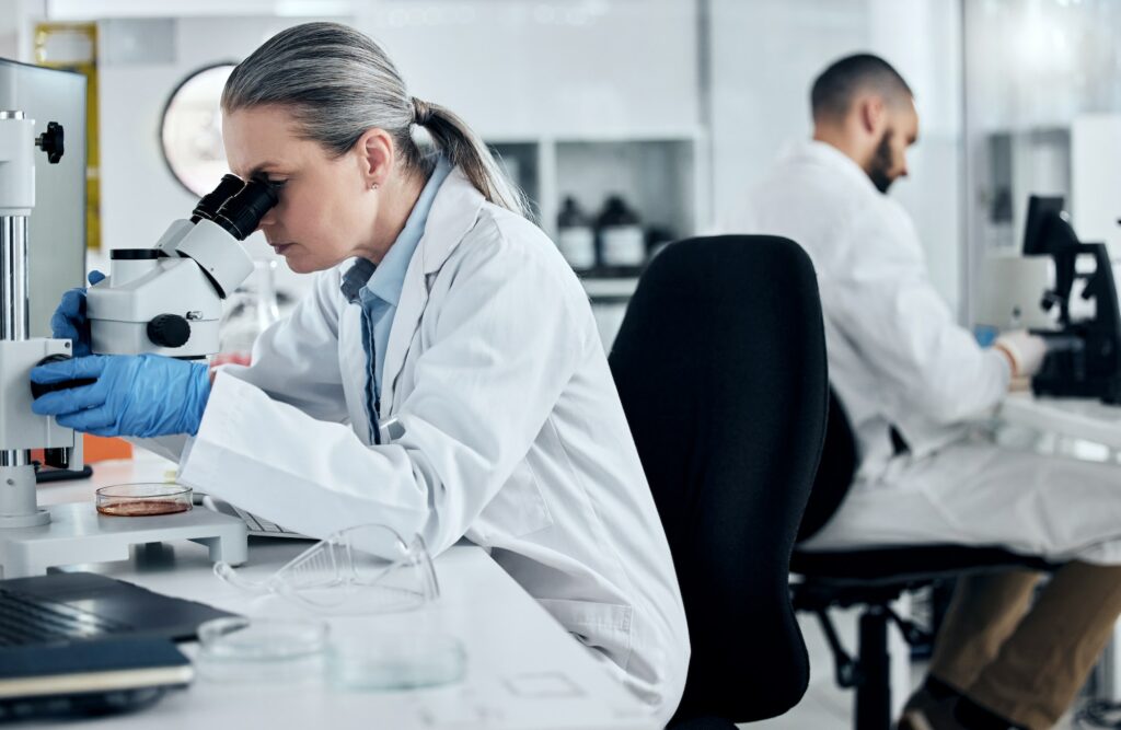 Laboratory woman, microscope or medical research of covid sample, cancer biopsy or DNA engineering